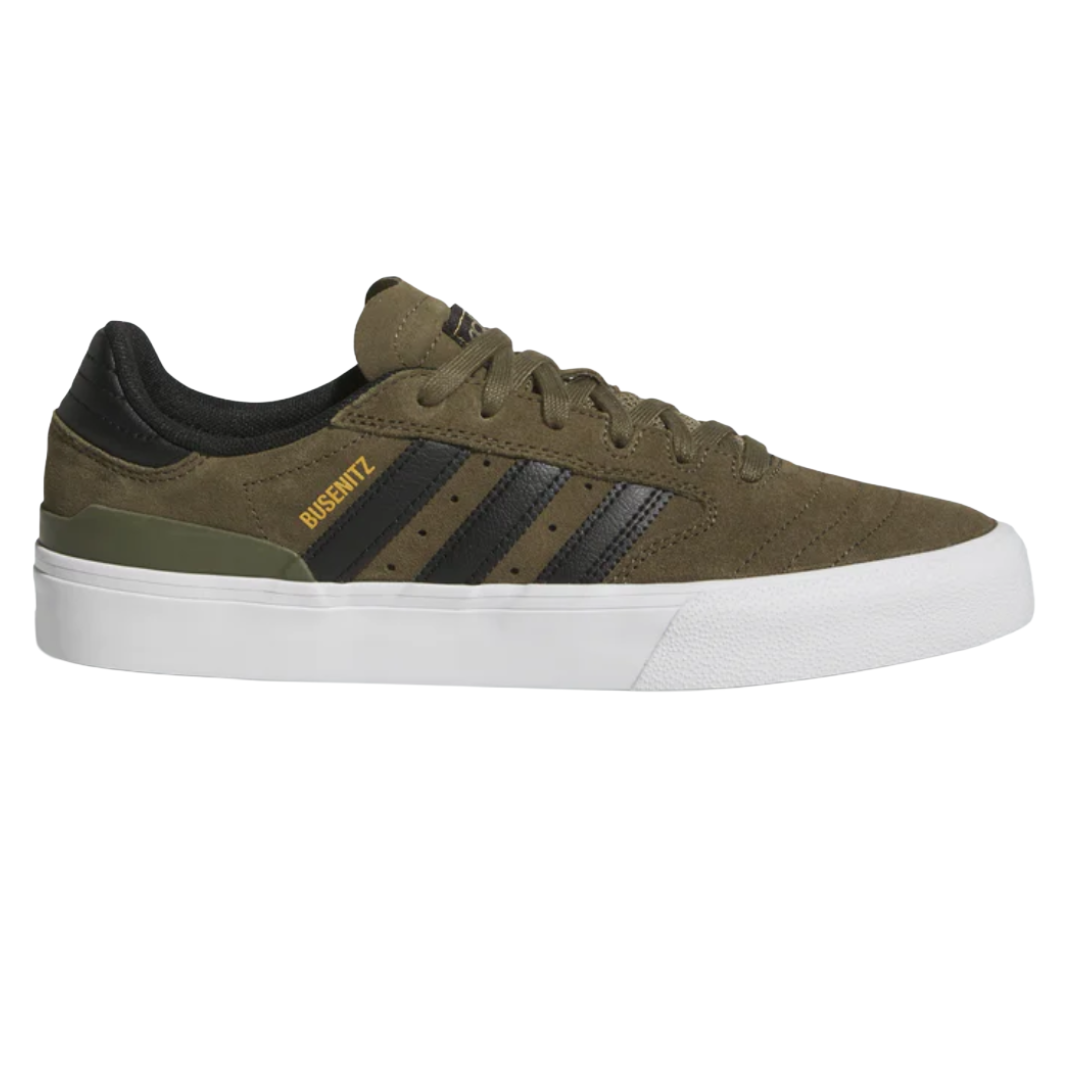 Olive green Adidas skate shoe with black stripes, white sole, and yellow \“BUSENITZ\“ text on the side.