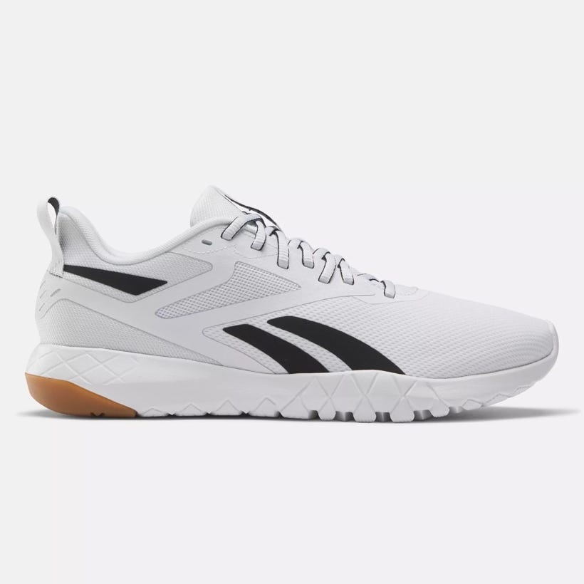 White athletic shoe with black accents and a tan sole, featuring a low-top design and lace-up closure.