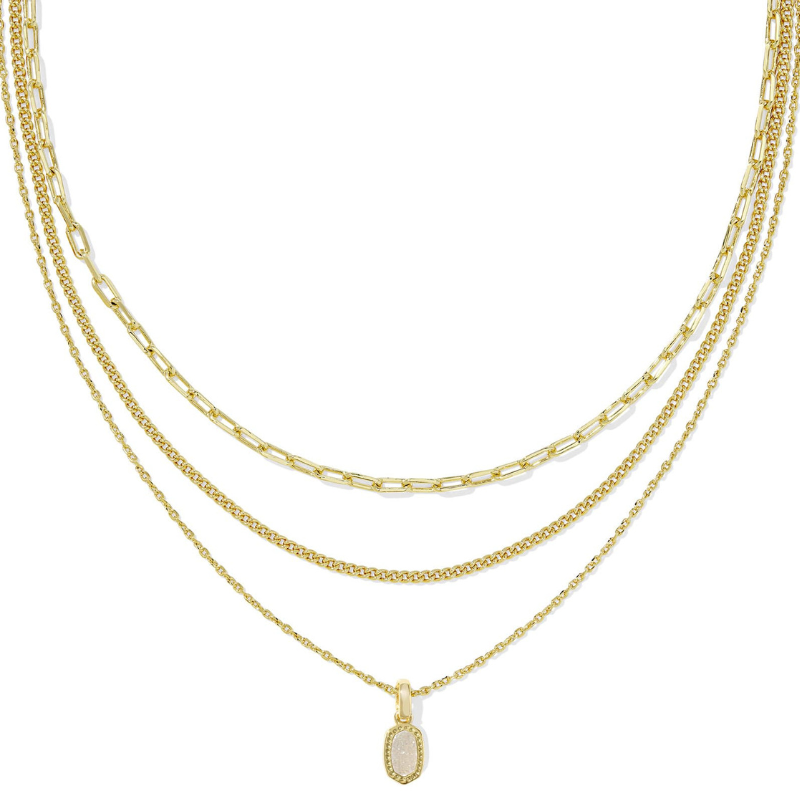 A gold triple strand necklace featuring a mix of chain styles and a small pendant with an oval-shaped stone.