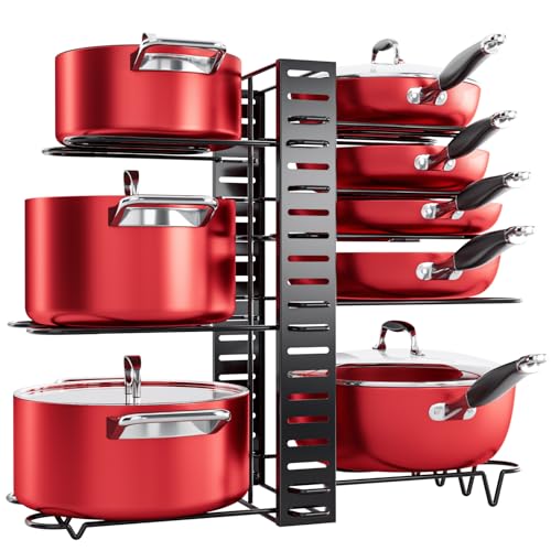 A red cookware set is organized on a tiered, black under-cabinet storage rack with slots for pans and hooks for lids.