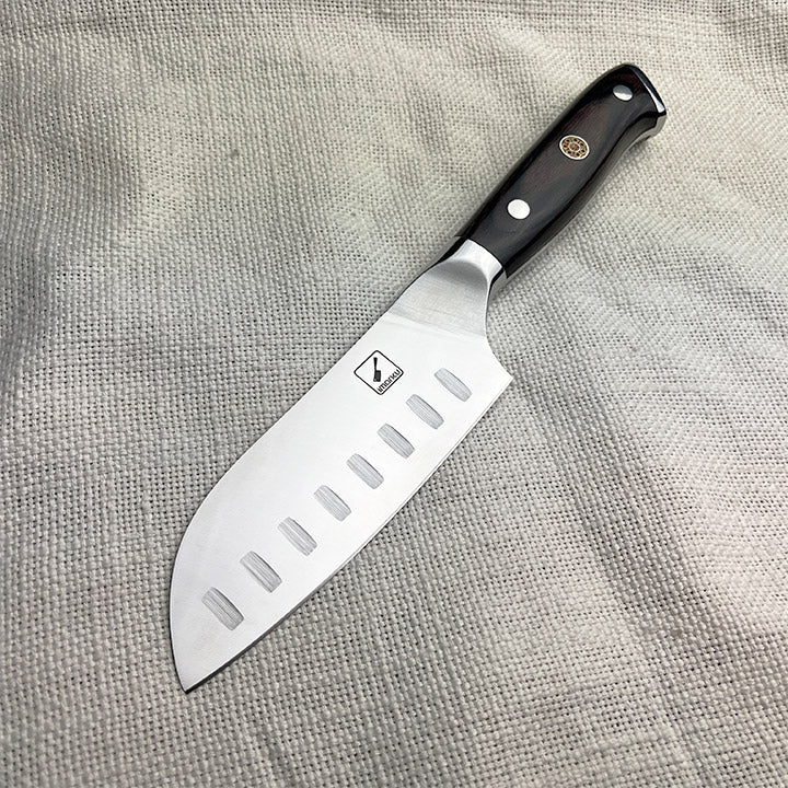 A chef's knife with a black handle and a row of rectangular cutouts along the blade.