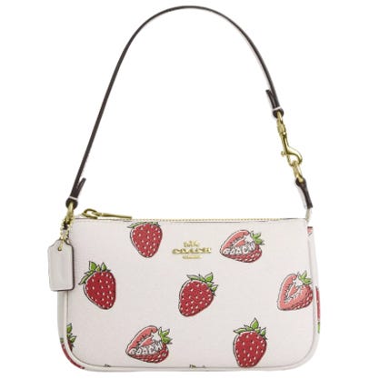 White Coach Nolita bag featuring a strawberry print, gold-tone hardware, a detachable strap, and a Coach logo on the front.