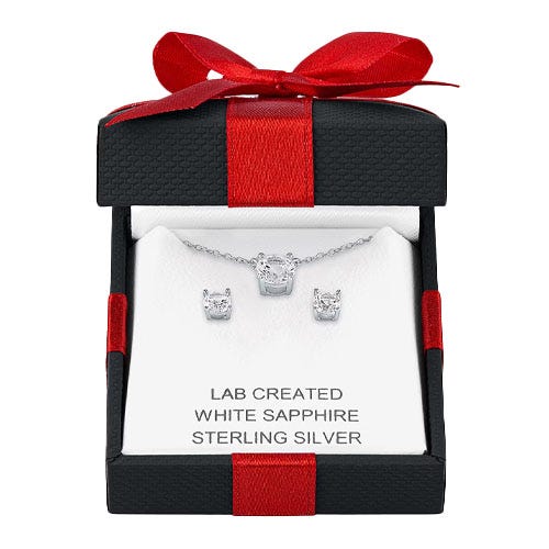 a pair of silver earrings and a necklace in a black box with a red bow