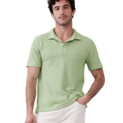 A man is wearing a light green short-sleeve polo shirt paired with white pants.