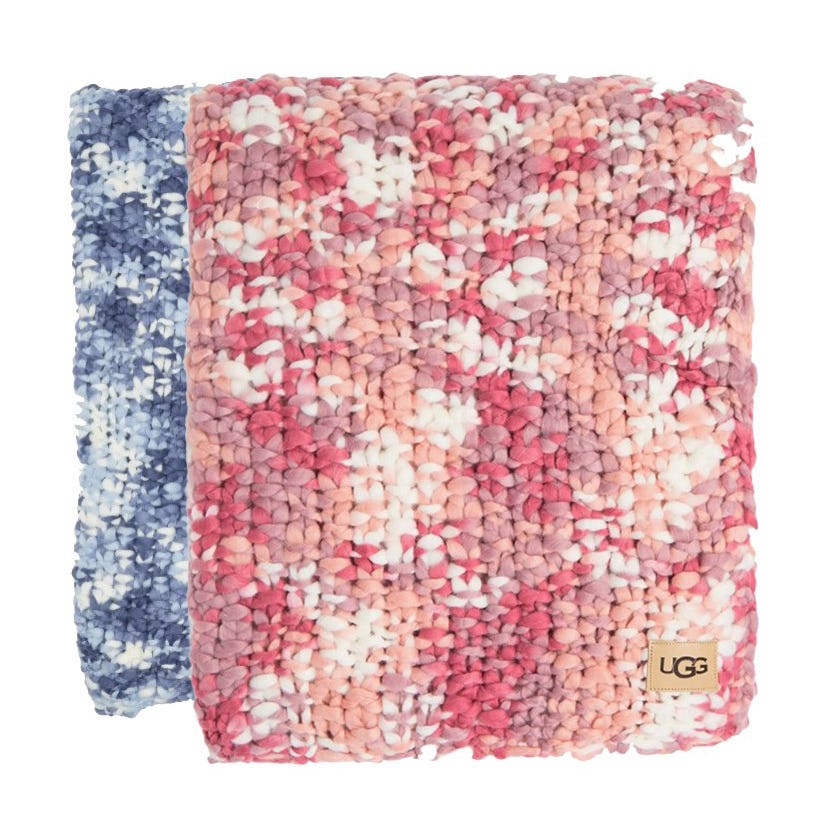 Two chunky knit blankets in blue and pink multicolored patterns, with a visible brand tag.