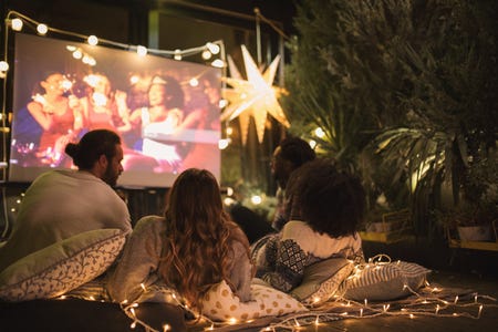 A family movie night outdoors with a projected film on a screen