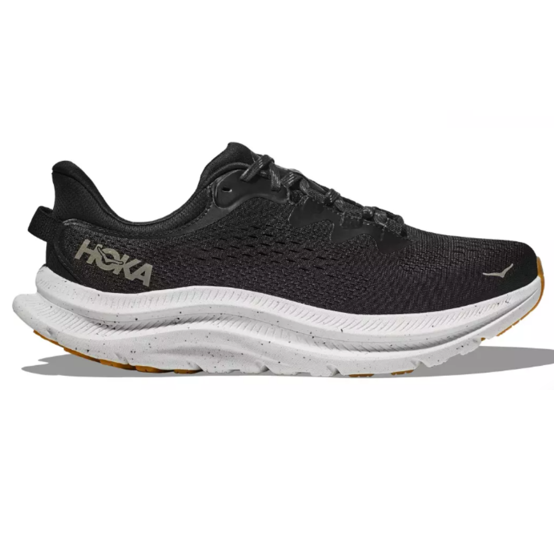 Hoka Men's Kawana 2 Shoes feature a black mesh upper with a white, textured midsole and rubber outsole. The design includes the Hoka logo on the side, offering cushioning and traction for running or casual wear.