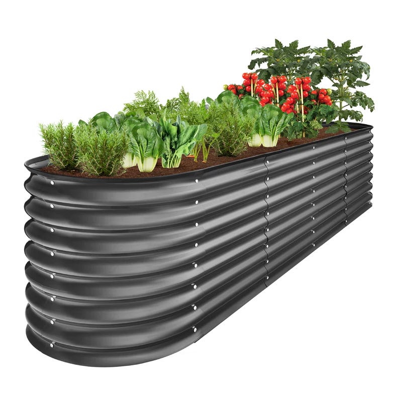 Raised garden bed with a variety of vegetables like tomatoes and lettuce in a curved, corrugated metal container.