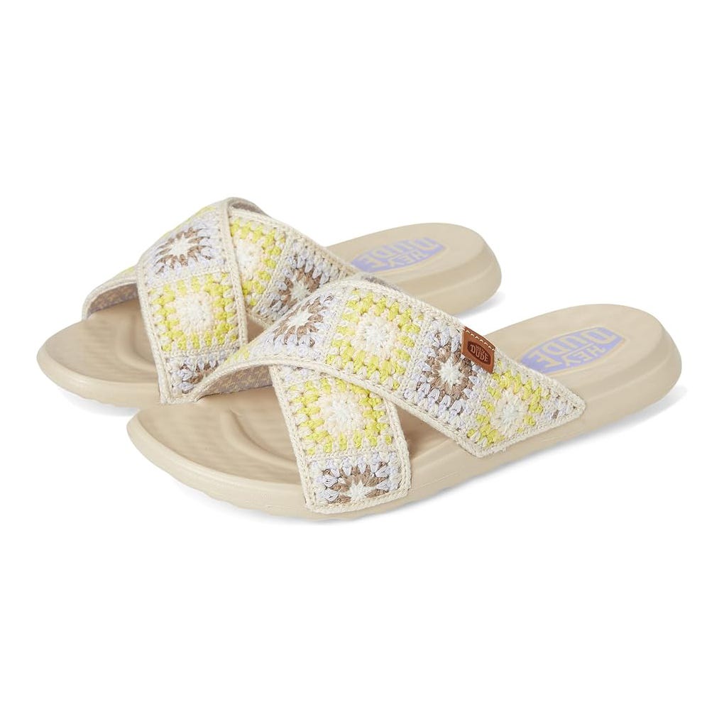 Crossover strap sandals with a crocheted pattern in yellow and beige on a neutral sole.