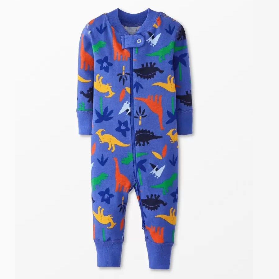 A blue children's onesie with a colorful dinosaur print.