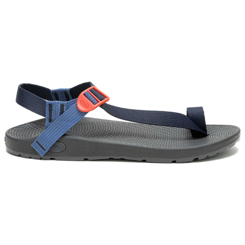 Men's Bodhi Sandal features adjustable navy blue straps with a red buckle and a black textured footbed, designed for comfort and support. The sandal has a sleek, minimalist look suitable for casual wear.