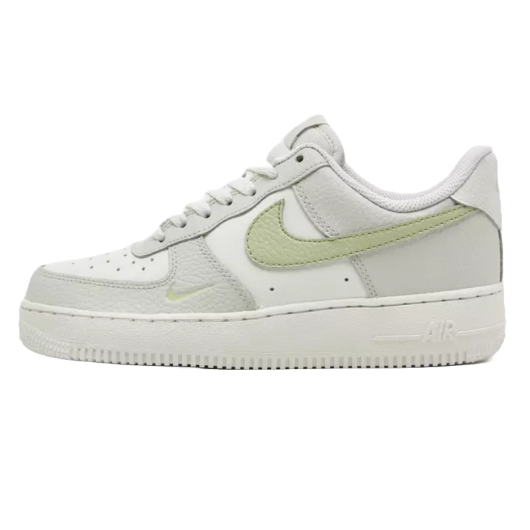 Nike Women's Air Force 1 Shoes feature a classic low-top design with a white leather upper and light green Swoosh. The shoe includes a perforated toe box and a thick, cushioned sole with \“AIR\“ branding.