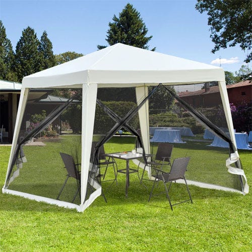 A white outdoor pop-up canopy tent with mesh sidewalls is set up on grass. Inside, there's a round table with four wicker chairs, providing a shaded seating area.