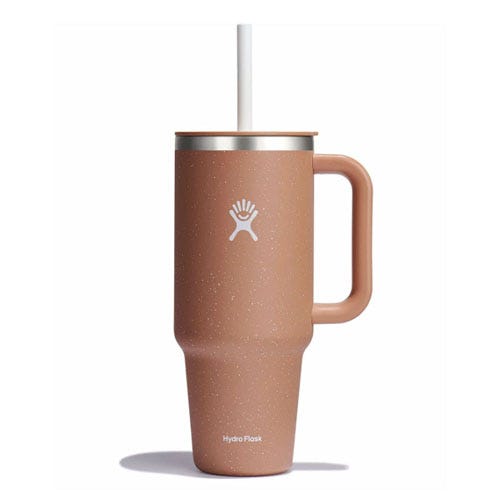 A tan Hydro Flask tumbler with a handle and straw, featuring the Hydro Flask logo on its side.