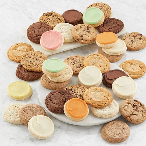 A variety of 36 cookies including chocolate chip, sugar, and frosted cookies in flavors like lemon, orange, pink, green, and cream, arranged on a marble surface.