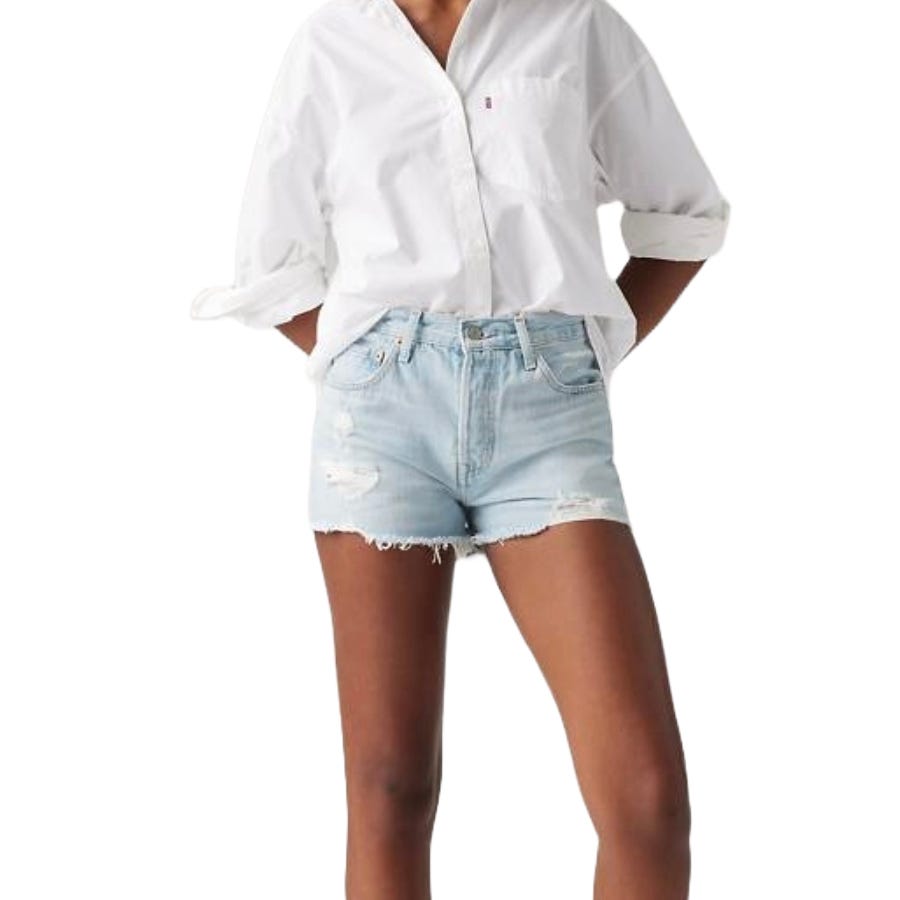 Levi's High-Rise Shorts feature a light wash with distressed details and frayed hems. They sit at the waist and offer a casual, laid-back look paired with a classic button-up white shirt.