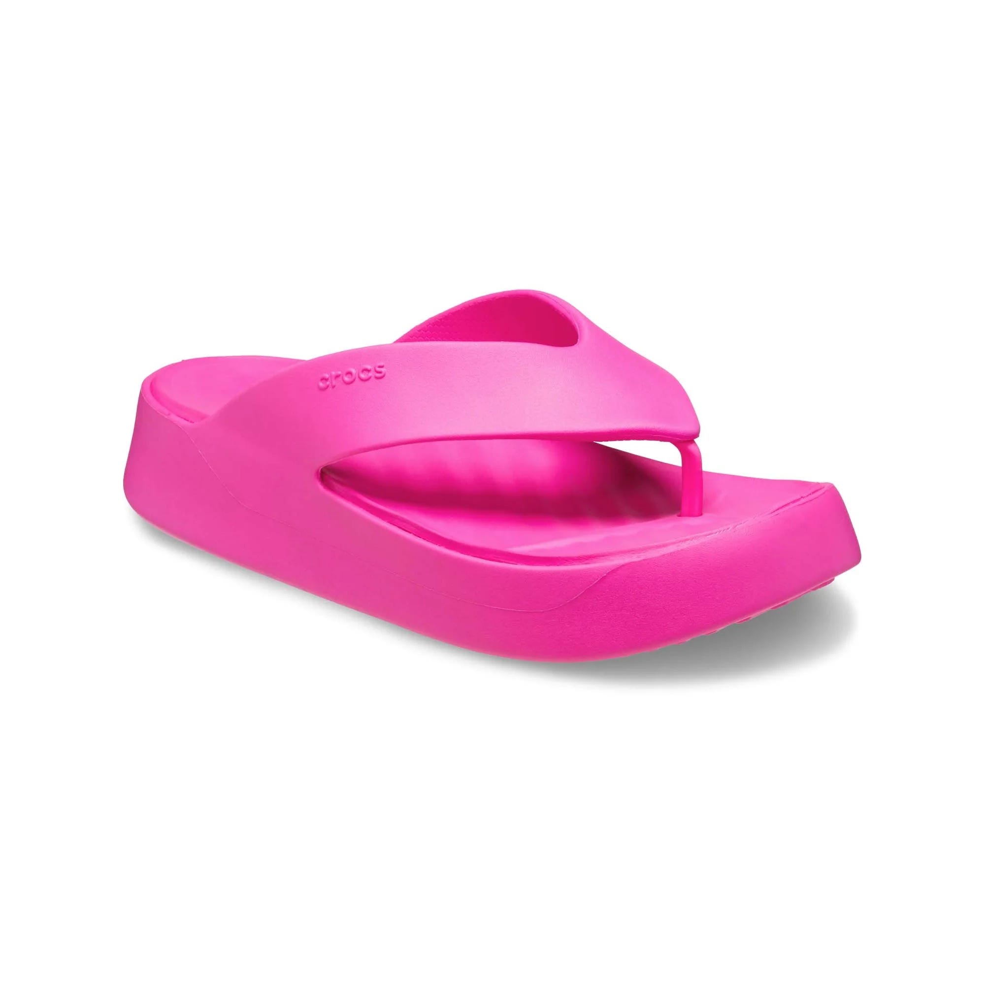 Bright pink platform flip-flops from Crocs with a wide strap and toe post. They feature a thick, contoured sole for added comfort.