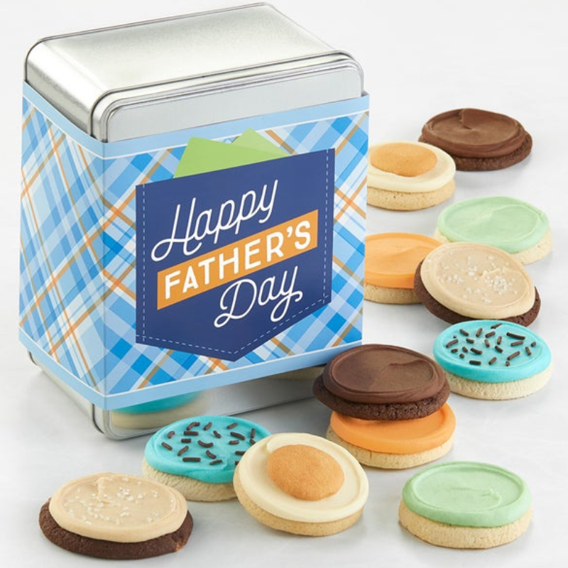 A tin adorned with a \“Happy Father's Day\“ design contains assorted frosted cookies in various colors like blue, green, orange, and chocolate, with some topped with sprinkles or sugar.