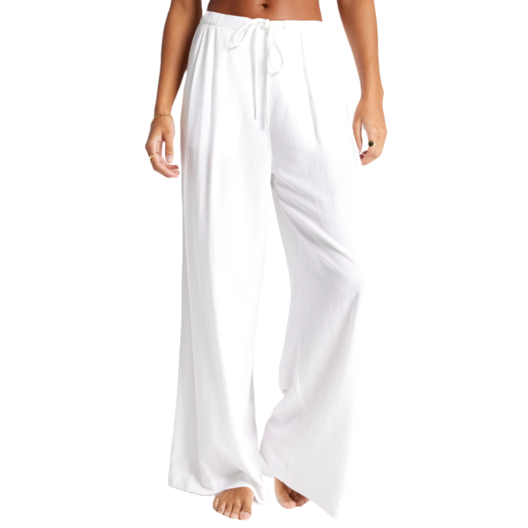 White wide-leg pants with an elastic drawstring waist, worn by a person without shoes.