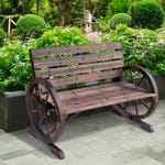 Wooden garden bench with wagon wheel armrests on a paved surface, surrounded by flowers and greenery.
