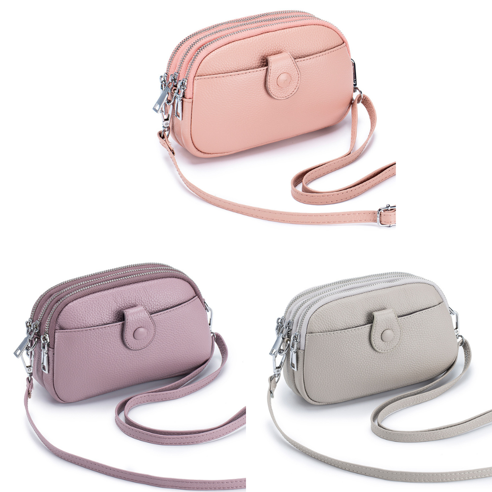 Three small shoulder bags in pink, purple, and grey, each with a long strap and front zipper.