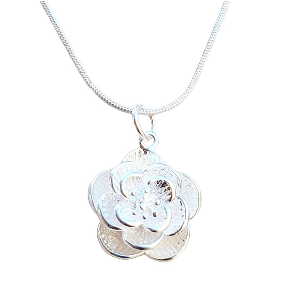 A silver chain necklace featuring a detailed flower-shaped pendant with layered petals and a textured surface.