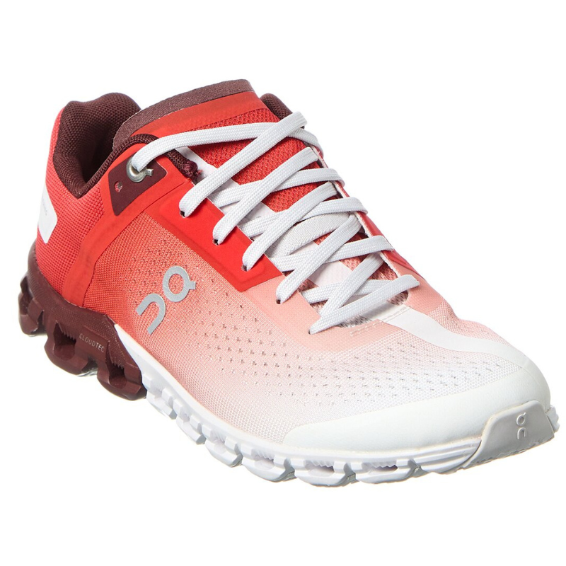 Red and white athletic shoe featuring a gradient design, white laces, and a distinctive CloudTec sole.