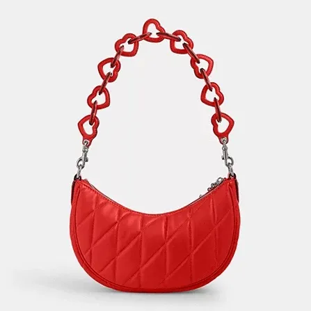 Red quilted half-moon shoulder bag with chunky chain link strap.