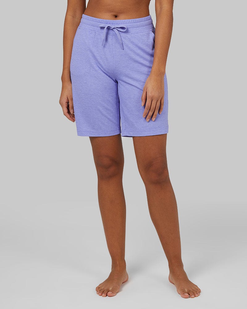 A person wearing light purple, casual drawstring shorts.
