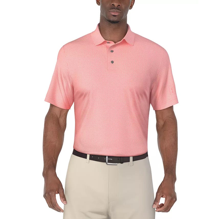 A man is wearing a light red or coral-colored short-sleeve polo shirt paired with beige pants and a black belt.