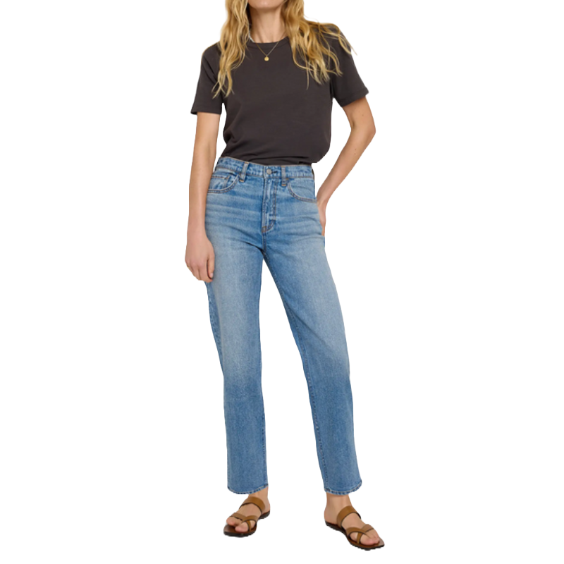A person wearing a black T-shirt, light blue high-waisted jeans, and brown sandals.