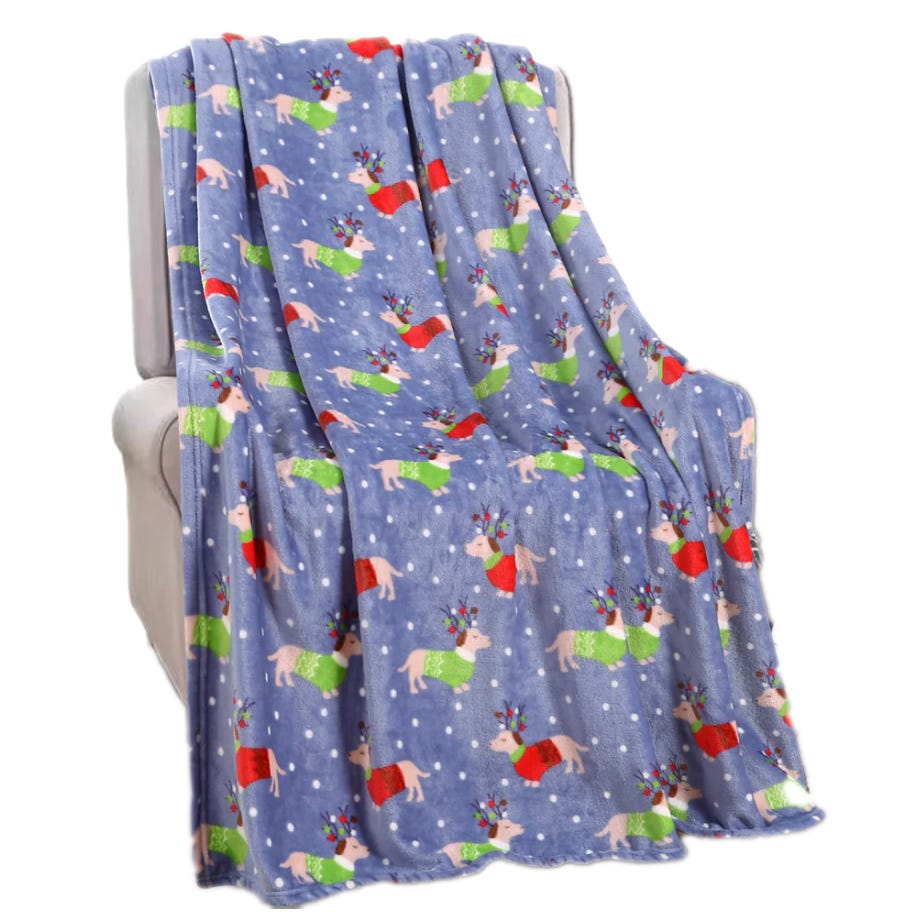A festive 50\“ x 60\“ holiday throw with a blue background featuring playful reindeer illustrations wearing colorful sweaters and antlers, surrounded by white snowflakes.
