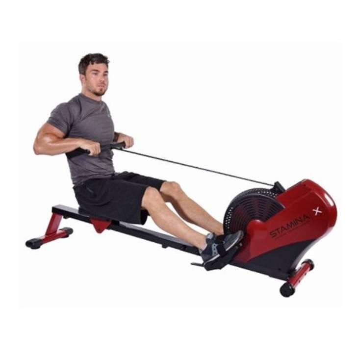 A man using a red and black indoor rowing machine.