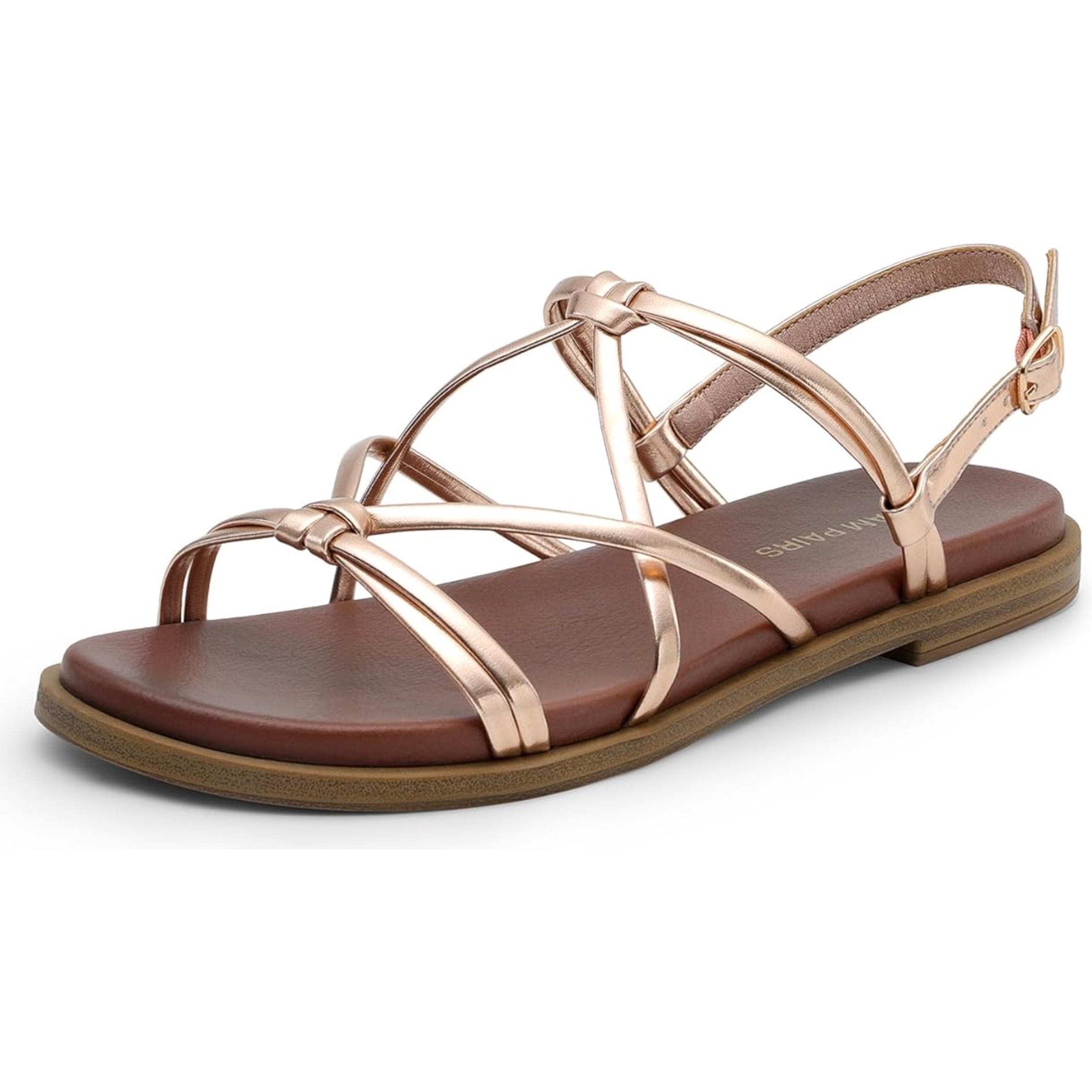 Rose gold gladiator sandals with a strappy design, featuring adjustable ankle straps and a brown cushioned footbed with a flat sole.