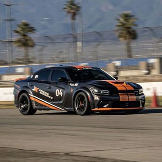 A black and orange-striped sports car racing on a track.