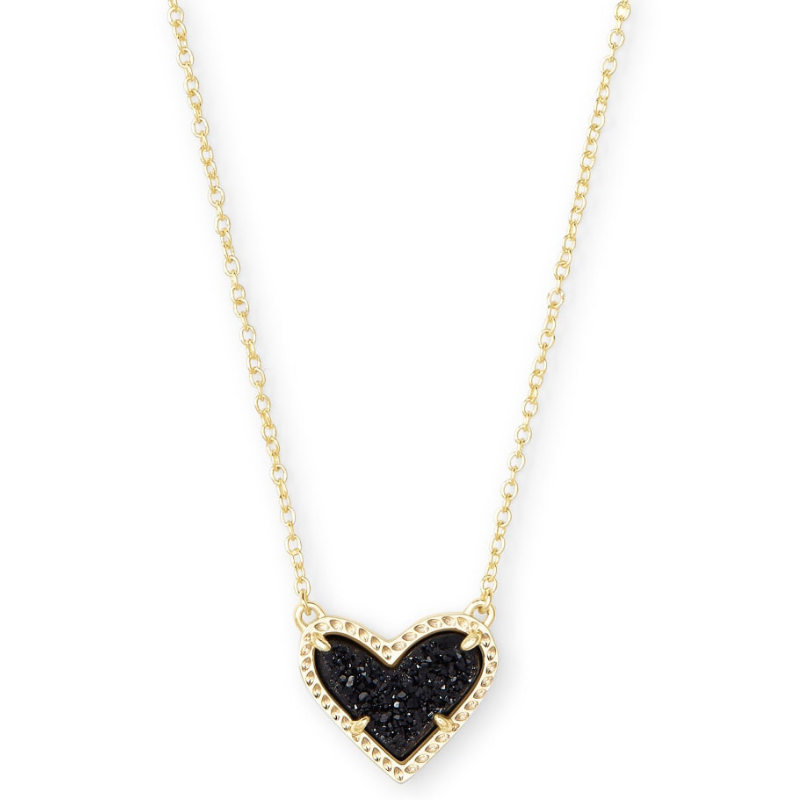 A gold necklace with a heart-shaped pendant featuring a textured black stone inlay, surrounded by a detailed gold border, attached to a delicate gold chain.