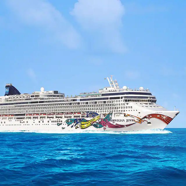 A cruise ship on blue ocean waters with colorful artwork on the hull.