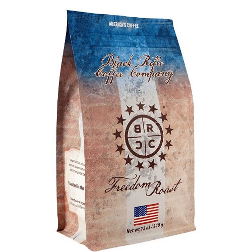 A 12oz package of Black Rifle Coffee Company's Freedom Roast, featuring a patriotic design with red, white, and blue colors, star accents, and an American flag image, indicating it is \“America's Coffee.\“
