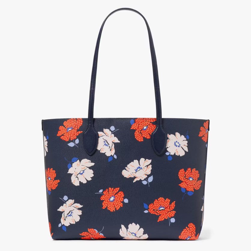 A navy blue tote bag with a floral print in shades of red, white, and blue.
