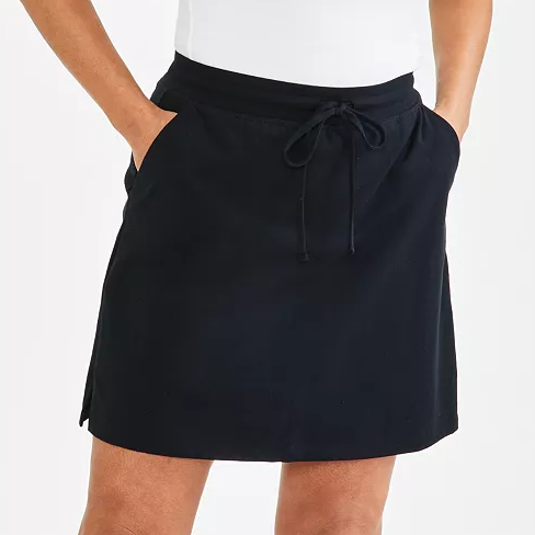 A person wearing a black drawstring skirt with side pockets.
