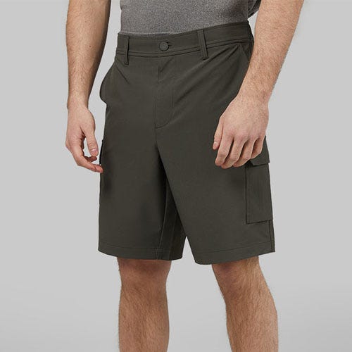 A man wearing olive green shorts with a side cargo pocket.