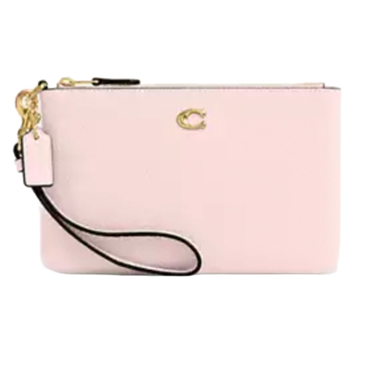 A light pink wristlet clutch with a gold-tone \“C\“ logo, leather strap, and attached tag.