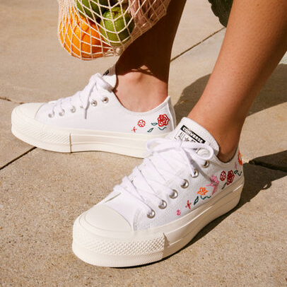 White sneakers with floral embroidery are shown.