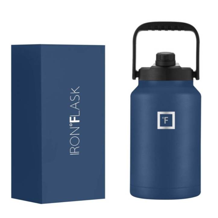 A blue IRON °FLASK water bottle with a black handle and spout next to its packaging box.