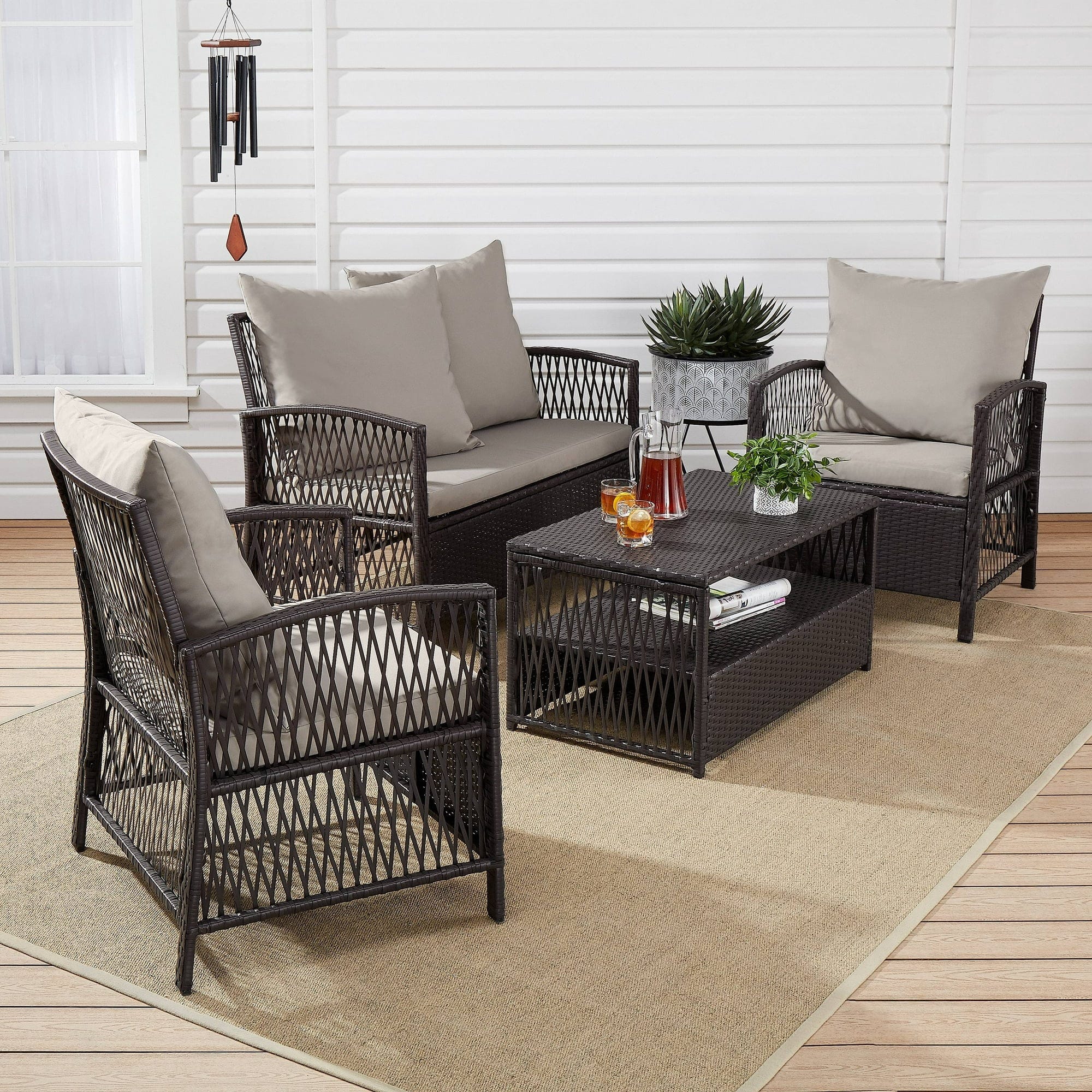 A patio furniture set with two chairs, a loveseat, and a coffee table, all in dark wicker with beige cushions.