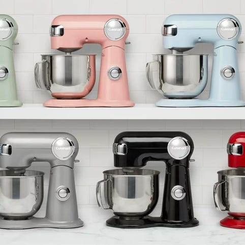 Six stand mixers in pink, blue, grey, silver, black, and red colors, arranged on two shelves.