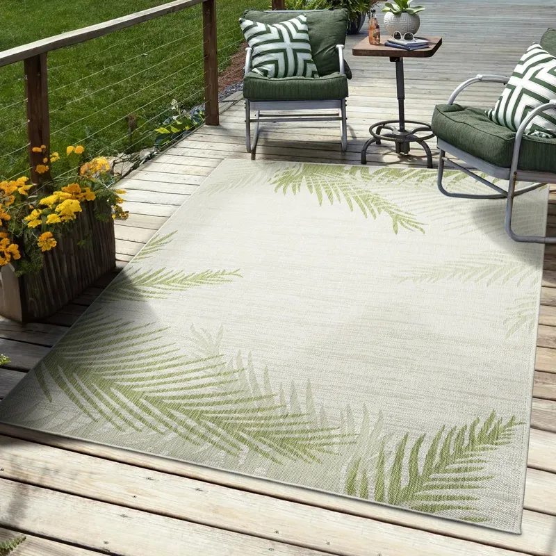 Outdoor patio area with two cushioned chairs, a side table, and a light-colored rug with leaf patterns.