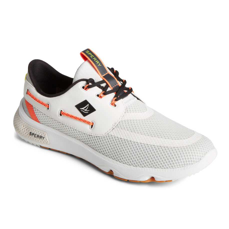 White sneaker with mesh upper, orange laces, and logo detail on side.