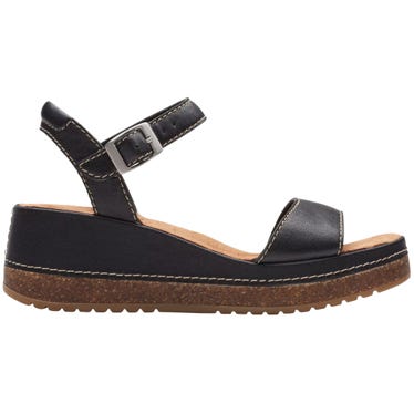 Black sandal with a wedge heel, featuring an ankle strap with a buckle and contrast stitching.