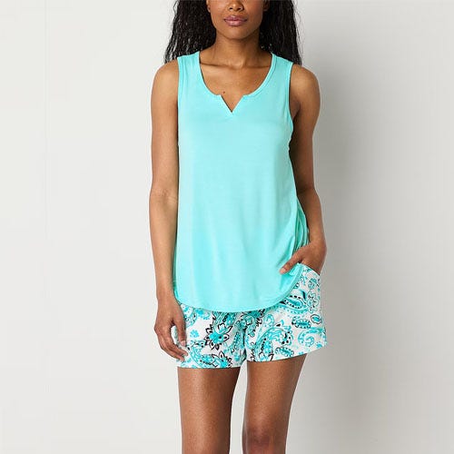 A woman wearing a light blue sleeveless top with a V-neck paired with matching floral print shorts.